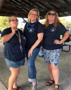 Three female staff members pose at picnic area